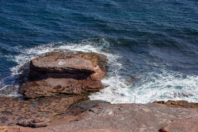 High angle view of waves splashing on rocks