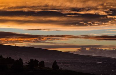 Scenic view of dramatic sky over landscape during sunset