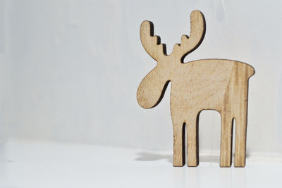 Close-up of deer on table against wall