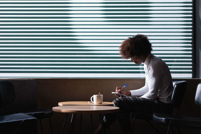 Woman sitting on table at home