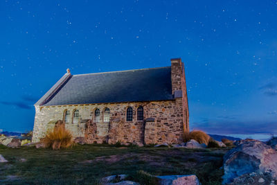 Castle against clear blue sky at night