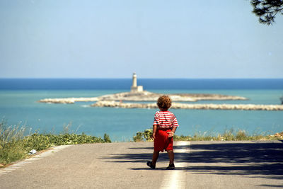 Rear view of woman looking at sea against sky