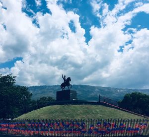 Statue on landscape against sky