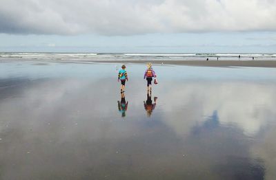 People on beach against sky