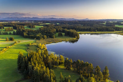 Aerial view of lake and landscape against sky during sunset