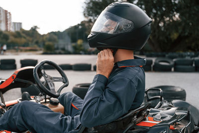 Side view of man driving car