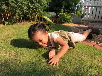 Happy girl playing on grass in park