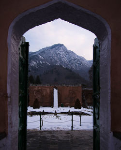 Built structure on snow covered mountain against sky