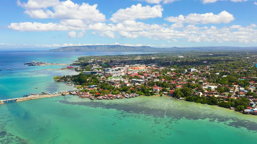 High angle view of city by sea against sky