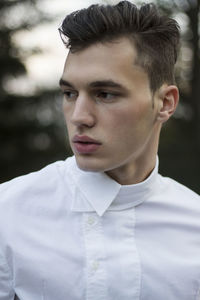 Close-up of thoughtful young man standing outdoors