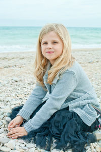 Portrait of young woman sitting at beach