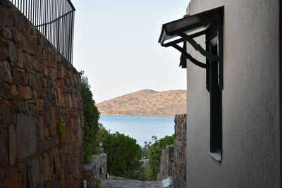 Buildings by sea against clear sky