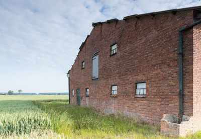 Old house on field against sky