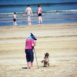 Rear view of men with dog on beach