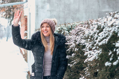 Portrait of smiling young woman standing in snow