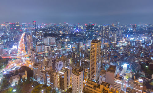 High angle view of illuminated buildings in city at night