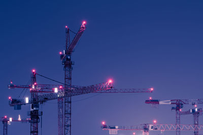 Cranes against clear sky at night