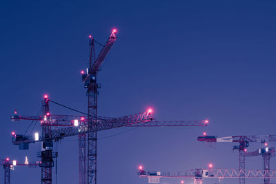 Cranes against clear sky at night