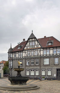 Houses by building against sky