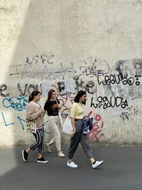 People standing against graffiti wall