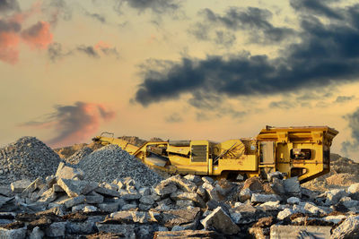 Yellow construction site against sky during sunset