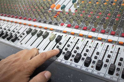 Cropped hand of man using sound mixer