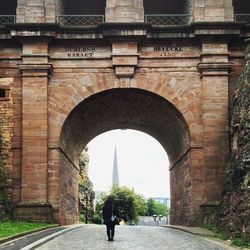 Rear view of man walking on bridge