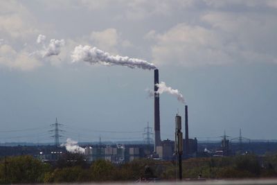 Smoke emitting from chimney against sky