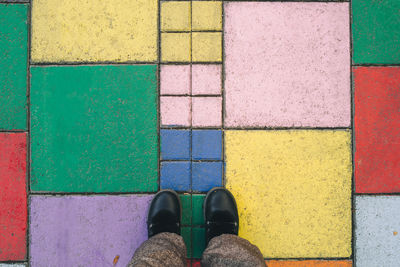 Personal perspective woman standing on the road painted in multicolored cubes in akureyri iceland