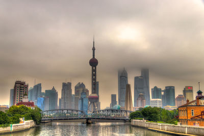 Modern buildings in city against cloudy sky