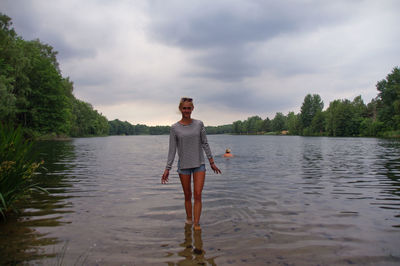 Portrait of smiling young woman standing in lake