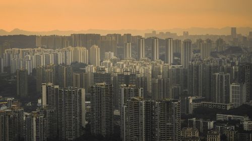 Aerial view of buildings in city against sky during sunset