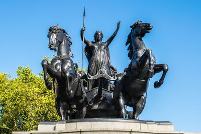 Low angle view of statue against clear blue sky