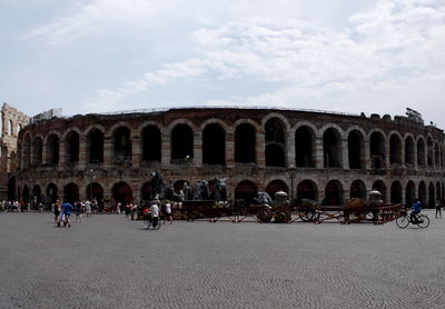 People at historical building against sky