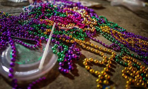 Mardi gras beads and drink caps littering the streets in the aftermath of a mardi gras parade 