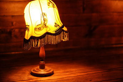 Close-up of illuminated lamp hanging on table