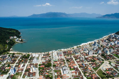 High angle view of townscape by sea against sky