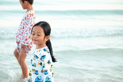 Cute girl with brother at beach