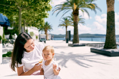 Mother and daughter on palm tree