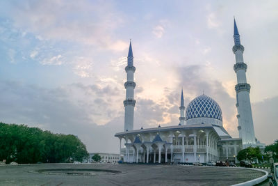 View of buildings in city against cloudy sky