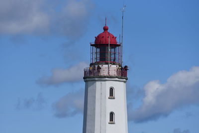 Low angle view of lighthouse by building against sky