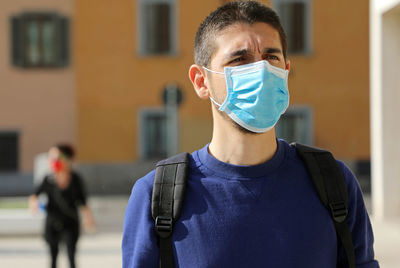 Close-up of man wearing mask looking away while standing outdoors