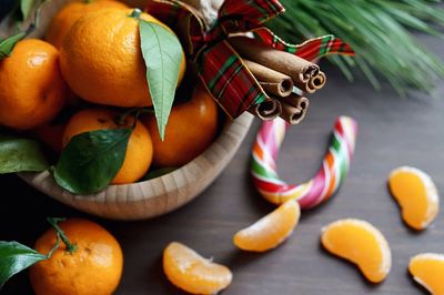 Close-up of orange fruits and cinnamon sticks on table