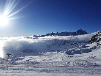 Scenic view of snowcapped mountains against clear blue sky