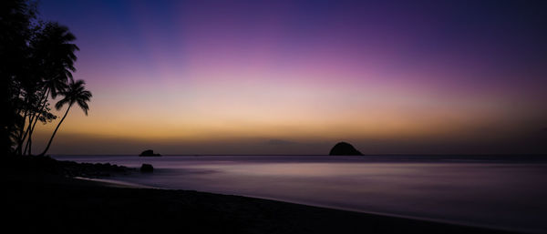 Scenic view of beach against sky at dusk