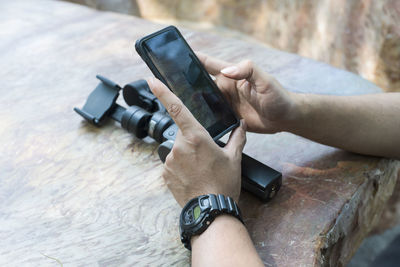 Midsection of man photographing with mobile phone