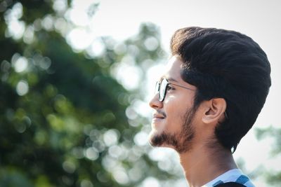 Profile view of young man standing outdoors