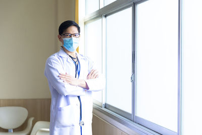 Full length of man standing by window