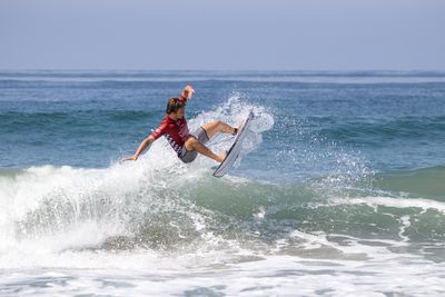 Man surfing in sea against sky