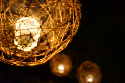 Low angle view of illuminated lights against black background